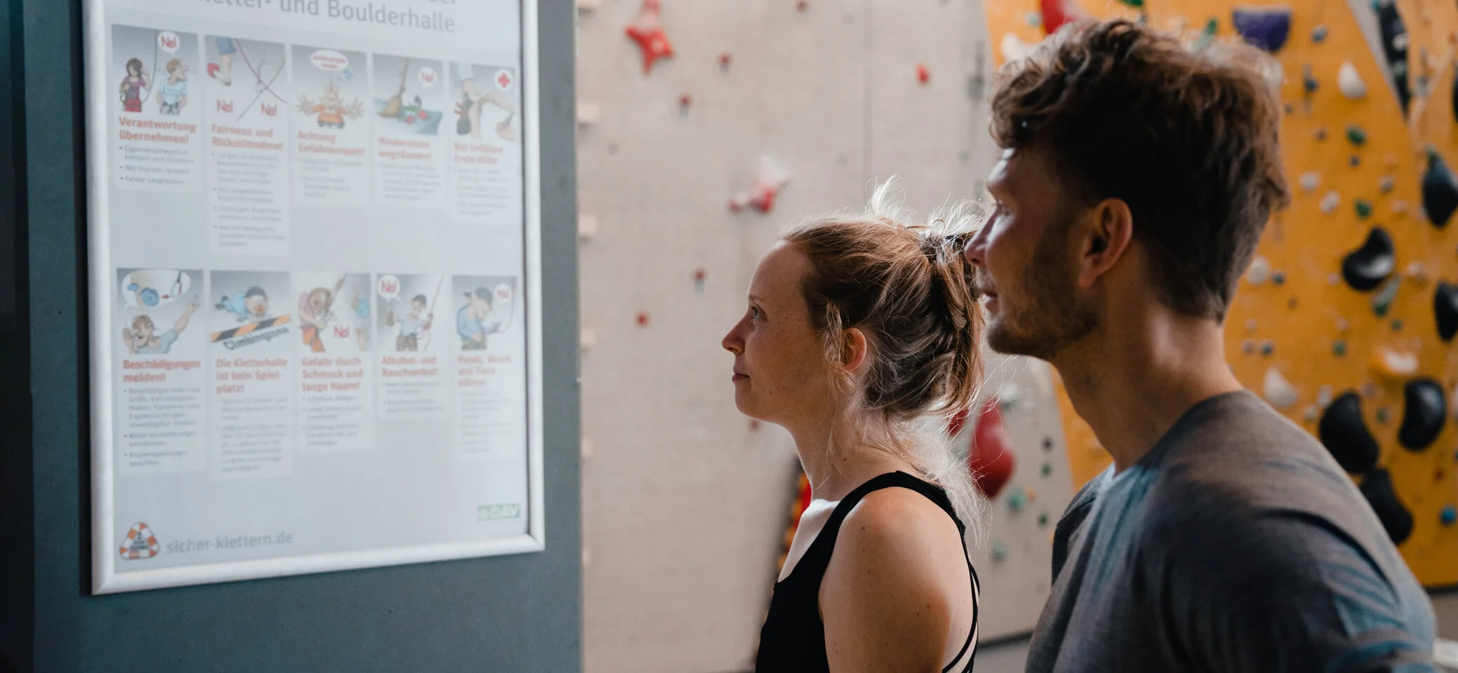 Boulder und Indoor-Klettern ist bei vielen DAV-Sektionen möglich | © DAV/Marisa Koch Zwei Personen checken den Trainingsplan, der an einer Wand hängt | © DAV/Marisa Koch