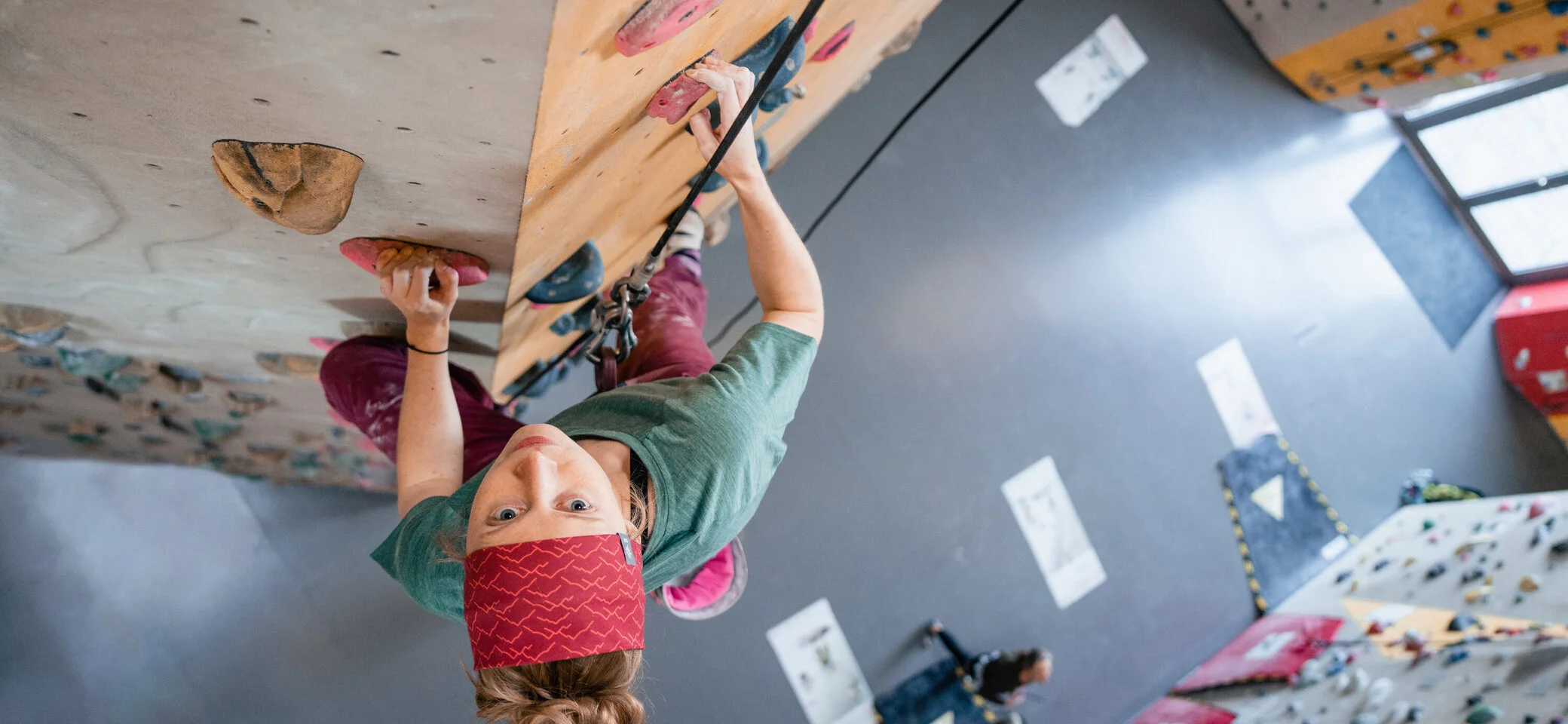 Eine Frau klettert in einer Kletterhalle, ihr Partner sichert sie. | © DAV/Marisa Koch